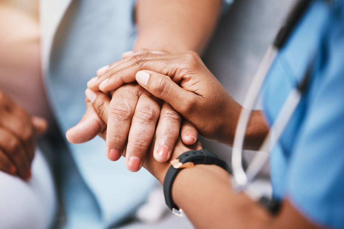 Close-up of medical technician holding patient's hands