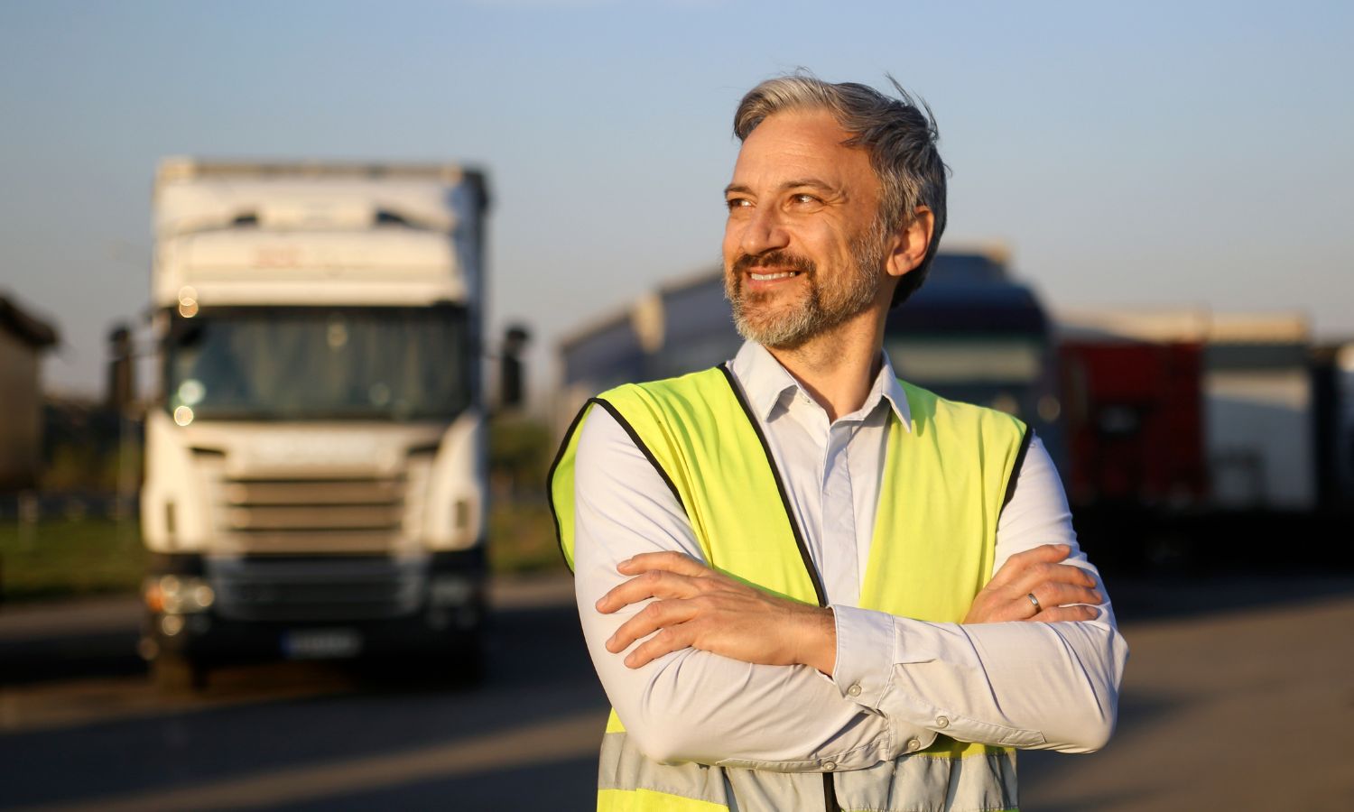 Man standing in front of truck wearing a yellow safety vest
